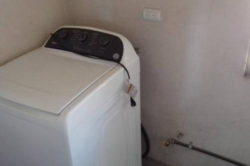 a washer and dryer in a corner of a room at Acogedor Departamento con estacionamiento gratuito in Monterrey