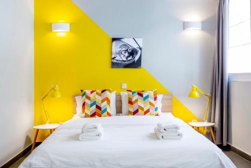 a bedroom with a large bed with a yellow wall at Monastiraki Place in Athens