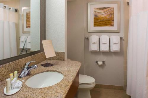 a bathroom with a sink and a toilet and a mirror at Sonesta Select Boston Lowell Chelmsford in Lowell