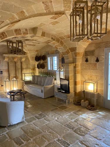 uma sala de estar com um sofá e uma TV em Masseria Curice em Corsano