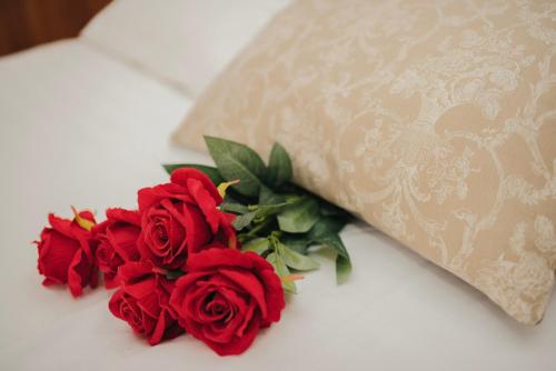 a group of red roses sitting next to a pillow at Hotel - Villa Lejla in Mostar