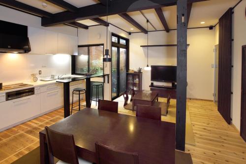 a kitchen and living room with a table and chairs at Kyoto Guesthouse Roujiya in Kyoto