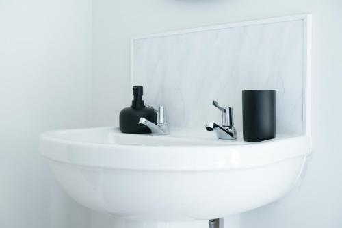 a white bathroom sink with two faucets on it at Cannock 3 bedroom house - perfect for work or leisure in Great Wyrley