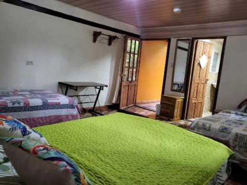 Habitación con 2 camas y manta verde. en CreaDora, en Boquete