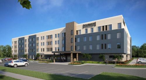 a building with a car parked in a parking lot at Staybridge Suites - Cincinnati East - Milford by IHG in Cincinnati