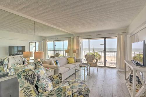 a living room with a couch and a tv at Ocean-View Balcony and Pool Access Galveston Gem! in Galveston