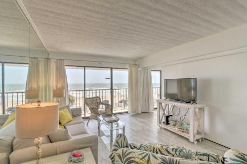 a living room with a couch and a television at Ocean-View Balcony and Pool Access Galveston Gem! in Galveston