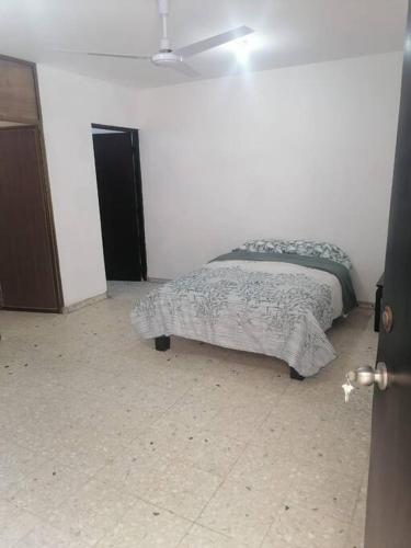 a bedroom with a bed in a white room at Hermoso departamento en Mazatlán in Mazatlán