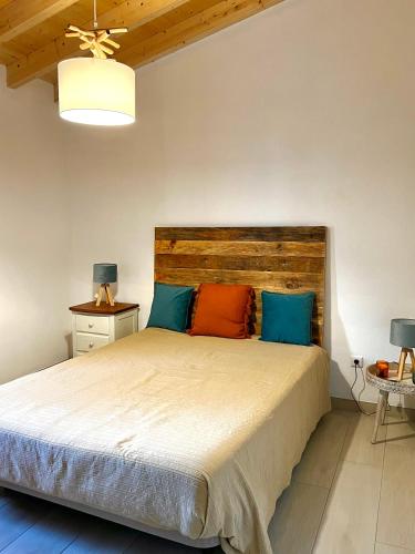 a bedroom with a large bed with blue and orange pillows at Casa da Cerca in Corte do Pinto