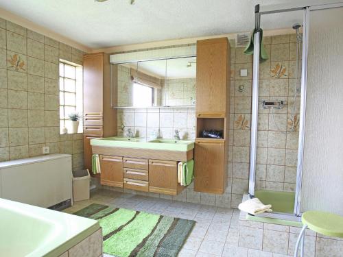 y baño con bañera, lavamanos y ducha. en Quaint Holiday Home In Girmont-Val-d'Ajol with Terrace, en Pracht