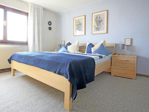 1 dormitorio con cama con sábanas azules y ventana en Quaint Holiday Home In Girmont-Val-d'Ajol with Terrace, en Pracht