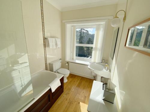 a bathroom with a tub and a toilet and a sink at Tyn Y Fron 6 bedroom house in Betws-y-Coed Snowdonia in Betws-y-coed