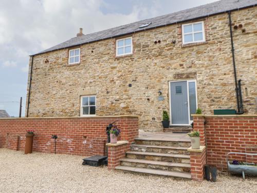 a brick house with a blue door and stairs at The Granary in Durham