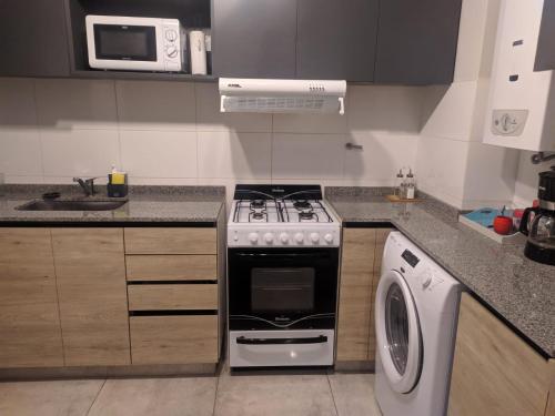 a kitchen with a stove and a washing machine at Departamento 2 dormitorios Nueva Cordoba in Cordoba