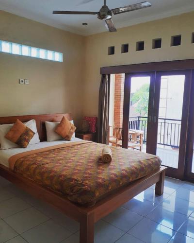 a bedroom with a large bed and a balcony at Nami House in Ubud