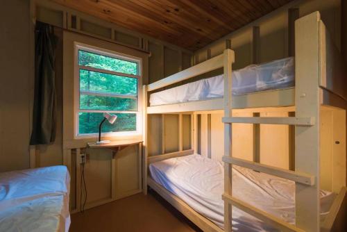 New Glasgow的住宿－New Glasgow Highlands Campground cabins，一间卧室设有两张双层床和一扇窗户。