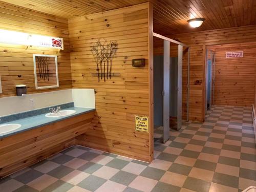 Baño con 2 lavabos en una pared de madera en New Glasgow Highlands Campground cabins en New Glasgow