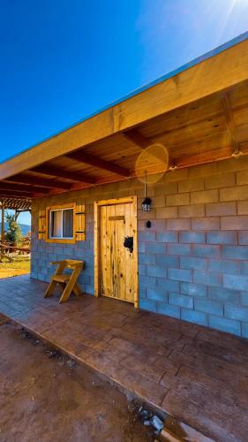 a building with a wooden door and a picnic table at Sn Tony Hotel & Spa in Valle de Guadalupe