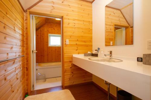 a bathroom with a sink and a toilet and a tub at Niseko HyKrots IKIGAI Village in Niseko