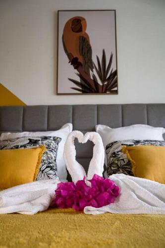 a bed with two swans and flowers on it at Appartement 2 chambres, avec jardin, grande terrasse, Barbecue, 8 min du centre ville in Fort-de-France