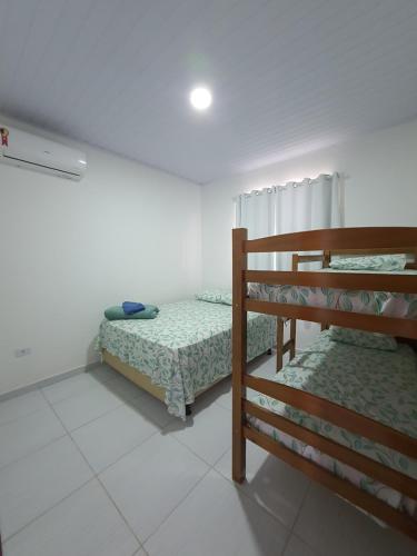 a room with two beds and a bunk bed at Chalés Cantinho Da Mary in São Miguel dos Milagres