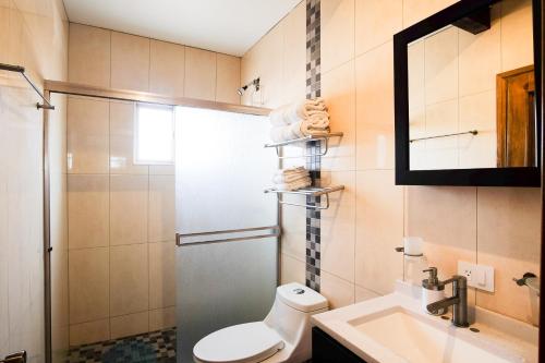 a bathroom with a toilet and a sink and a shower at Casa de Sara in Villa de Juárez