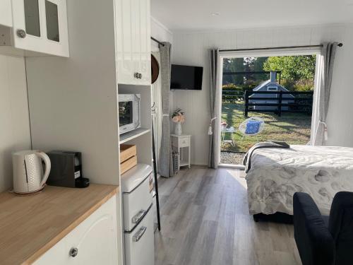 a bedroom with a bed and a door to a yard at Farm Stay HARMONY Cottage at Wilindi Estate in Tyabb