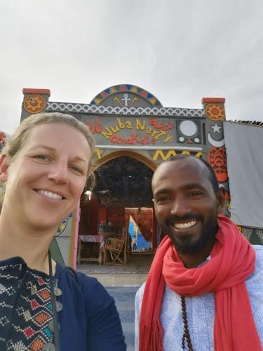 a man and a woman standing in front of a carousel at Nuba Narty in Aswan