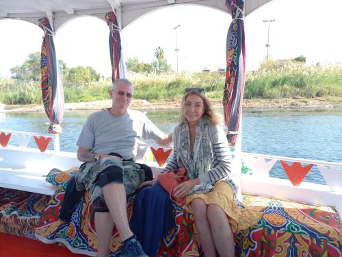 a man and a woman sitting on the back of a boat at Nuba Narty in Aswan
