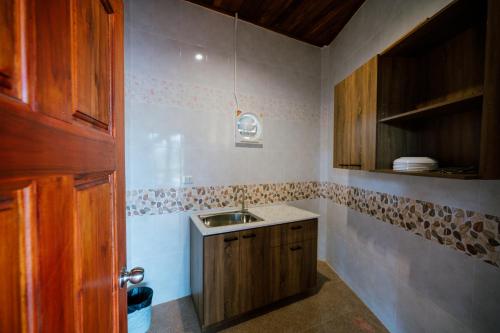 a kitchen with a sink and a wooden door at Tayama Farm Khaoyai in Nakhon Ratchasima