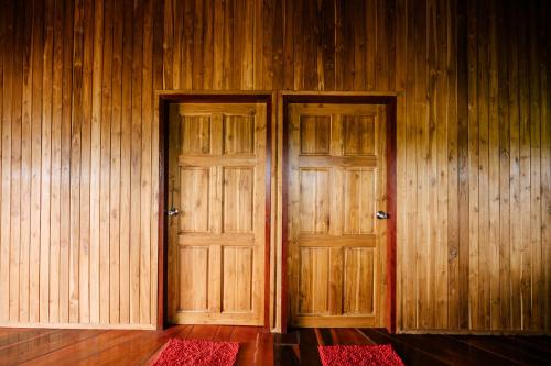 two wooden doors in a room with wooden walls at Tayama Farm Khaoyai in Nakhon Ratchasima