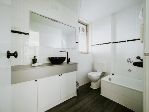 Un baño blanco con lavabo e inodoro. en SoYa Apartment Hotel, en Melbourne
