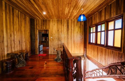 a room with wooden walls and wooden floors and a window at Tayama Farm Khaoyai in Nakhon Ratchasima
