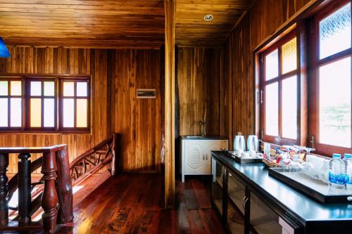 a kitchen with wooden walls and wooden floors and windows at Tayama Farm Khaoyai in Nakhon Ratchasima
