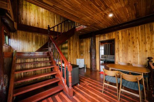 a room with a staircase and a table and chairs at Tayama Farm Khaoyai in Nakhon Ratchasima