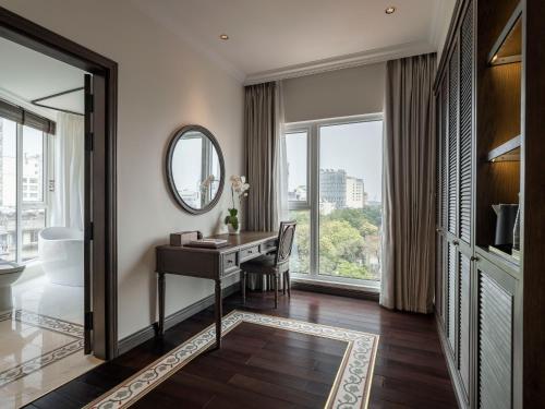 a hotel room with a desk and a mirror at De Syloia Hotel in Hanoi