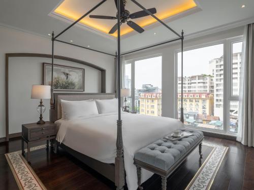 a bedroom with a large bed and a large window at De Syloia Hotel in Hanoi