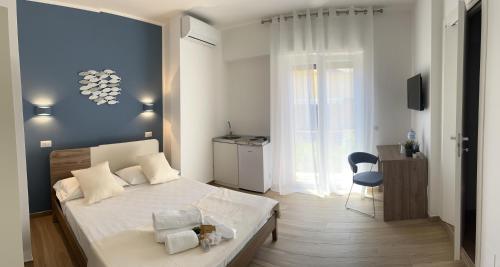 a bedroom with a white bed and a blue wall at Oltremare rooms Agropoli in Agropoli