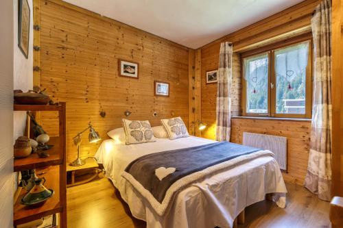 - une chambre avec un lit dans une pièce dotée de murs en bois dans l'établissement Maisonnette Argentée - Happy Rentals, à Chamonix-Mont-Blanc