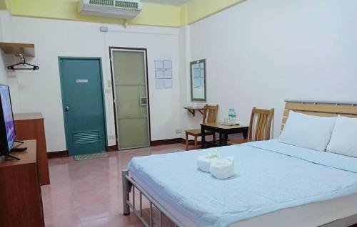 a bedroom with a large bed and a television at DD Mansion in Ban Talat Rangsit