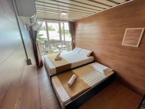 ein Zimmer mit zwei Betten und einem Fenster in der Unterkunft Paya Debloc Village in Tioman Island