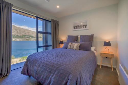 a bedroom with a bed with a view of the water at The Villa Lookout - Queenstown Holiday Villa in Queenstown