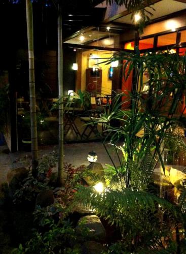 a garden with plants and lights at night at Pacific Palm Suites Davao powered by Cocotel in Davao City
