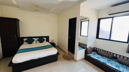 a bedroom with a bed and two windows at FARM HOUSE RESIDENCY in Vasai
