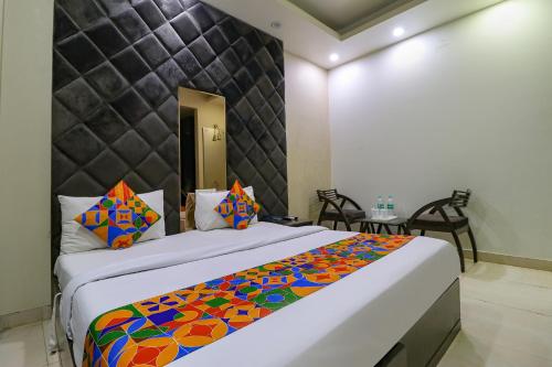 a bedroom with a large bed with a colorful blanket at FabExpress Yug Villa in New Delhi