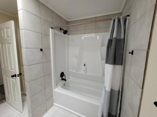 a white bathroom with a tub and a shower at Modern 10 Acre Horse Ranch-Walk to Lake Ray Robert in Pilot Point