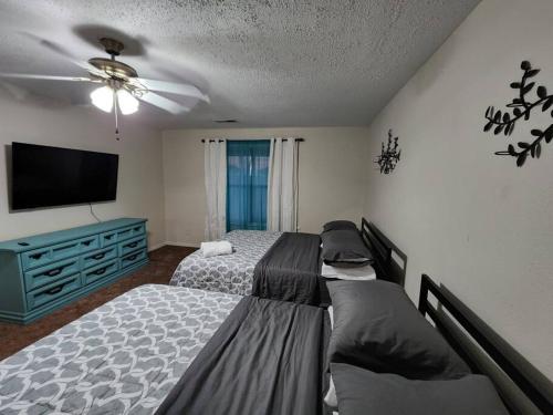 a bedroom with two beds and a flat screen tv at Modern 10 Acre Horse Ranch-Walk to Lake Ray Robert in Pilot Point