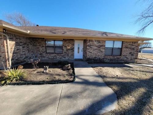 a brick house with a cat sitting in the front yard at Modern 10 Acre Horse Ranch-Walk to Lake Ray Robert in Pilot Point
