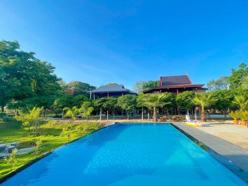 a swimming pool in front of a villa at บ้านสวนเปรมณัฐตรา in Ban Song (1)