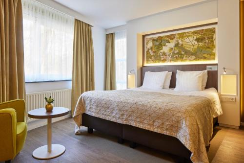 a hotel room with a bed and a chair at Auberge Du Bonheur in Tilburg